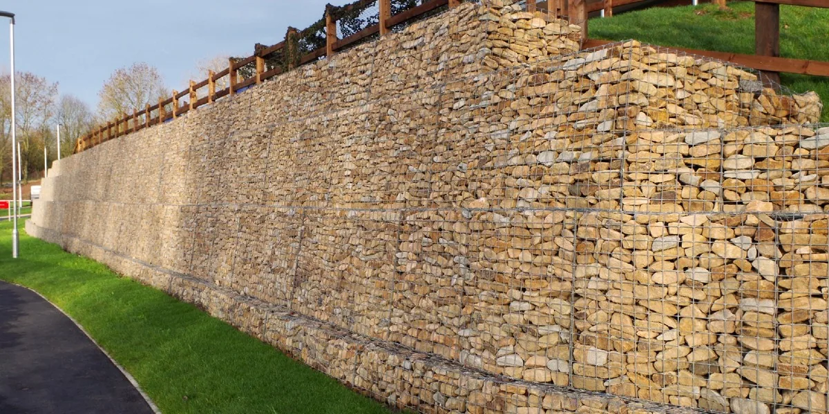 Stone-filled woven gabion mesh retaining wall